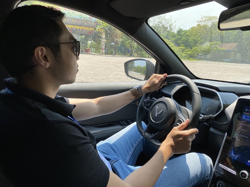 Người phụ nữ dùng điện thoại tại trạm sạc xe điện VinFast