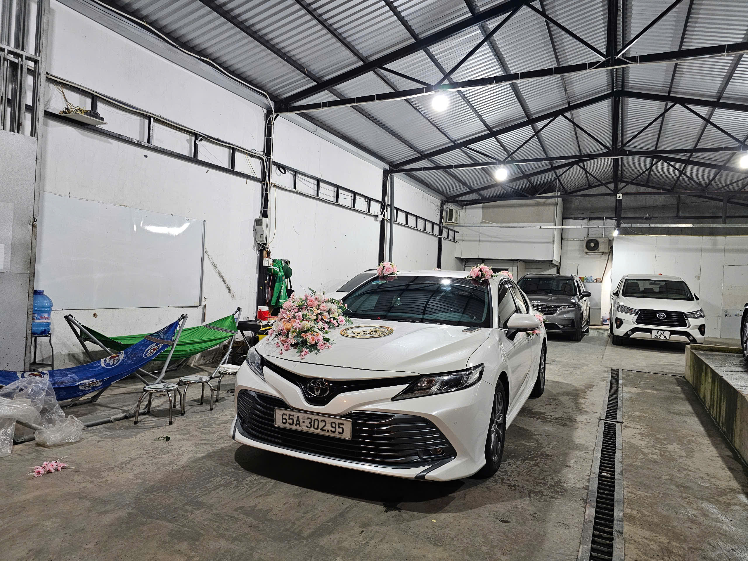 Phần đầu xe Toyota Veloz Cross 2023 màu trắng, nhìn trực diện. Xe có đèn pha LED hiện đại, lưới tản nhiệt lớn mạ chrome và logo Toyota.