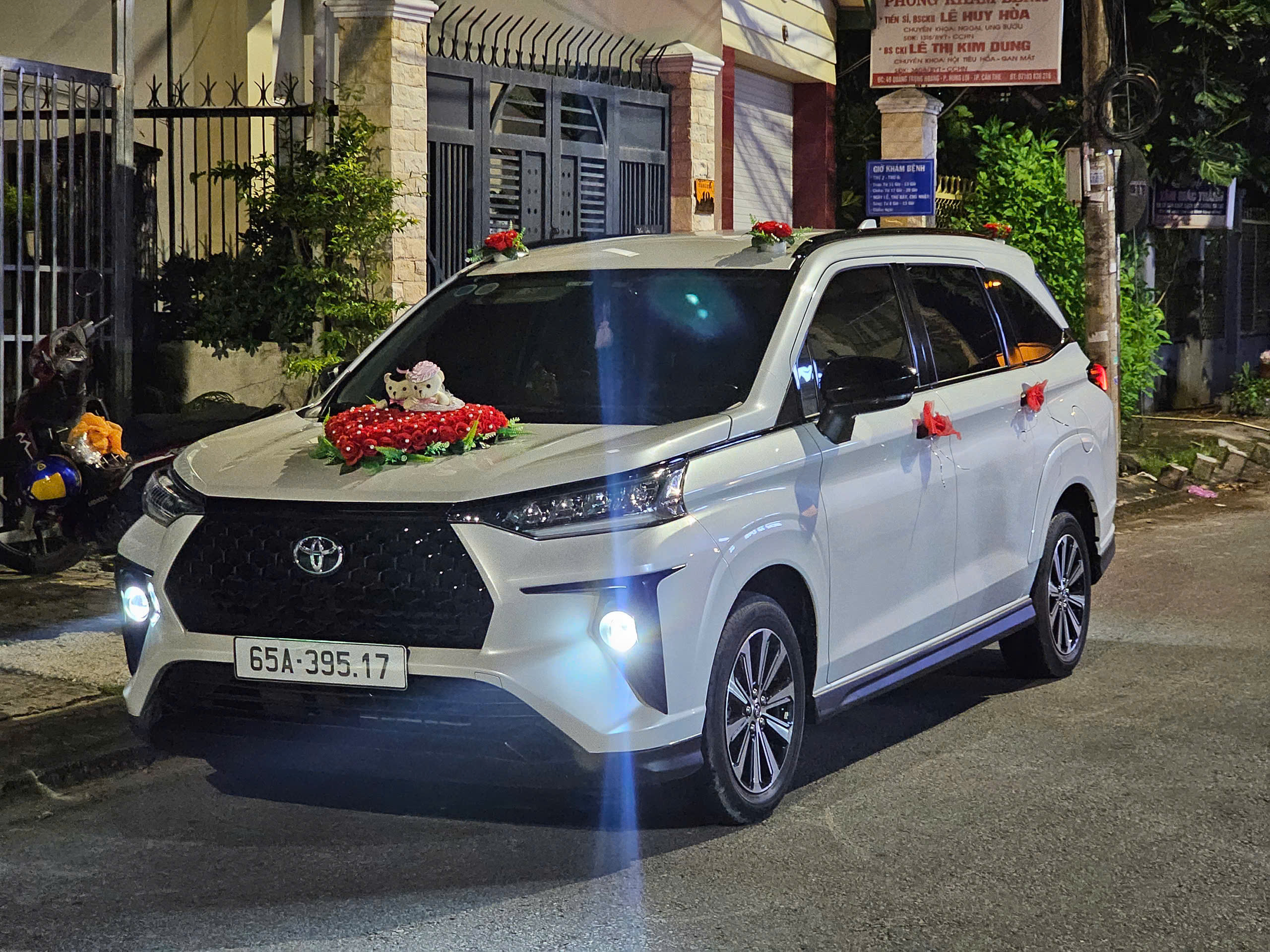 Xe Toyota Veloz Cross 2023 màu trắng, góc nhìn phía trước bên phải, đậu trên nền bê tông. Xe có đèn pha LED và lưới tản nhiệt lớn, thiết kế MPV 7 chỗ hiện đại.